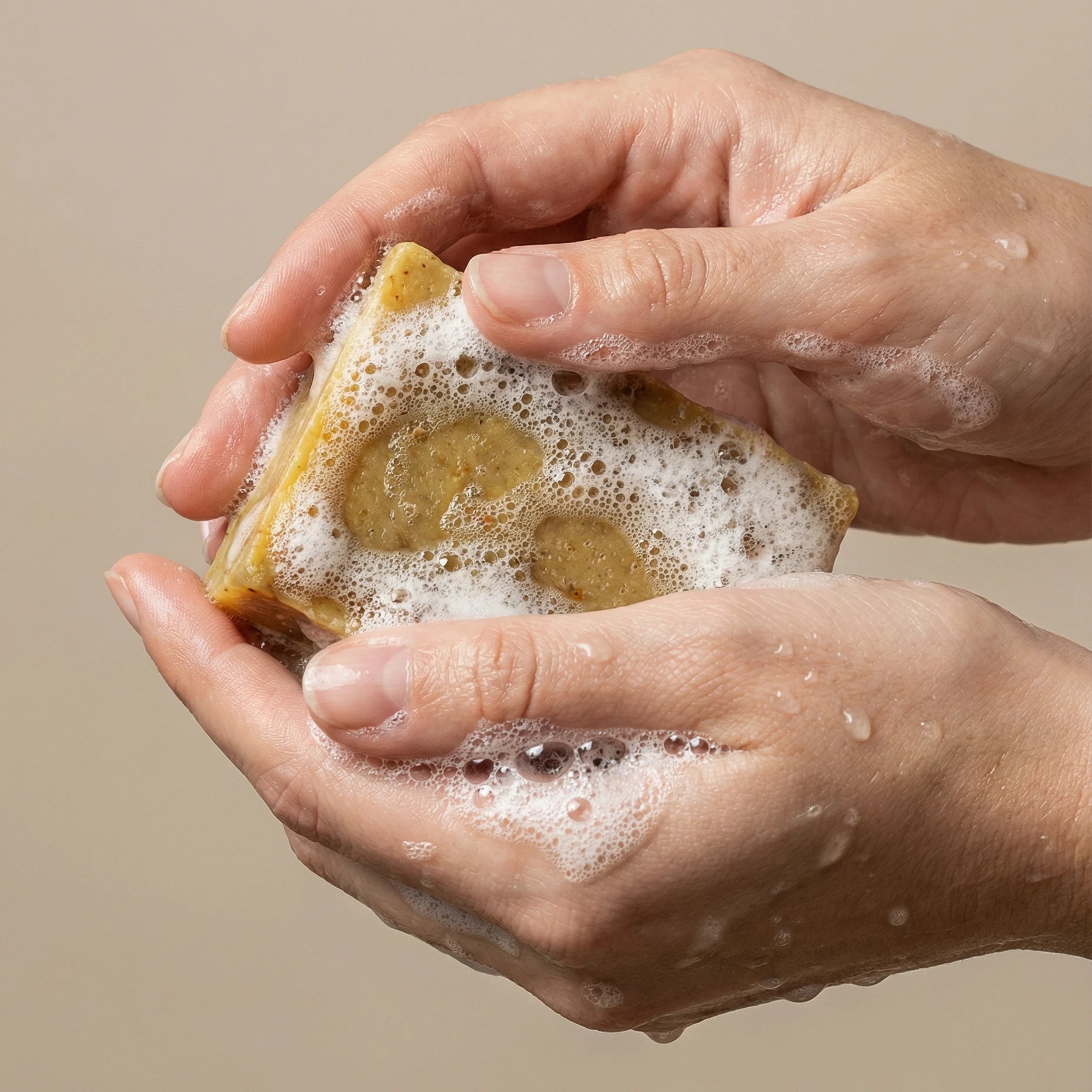 Savon à la cannelle mousseux entre deux mains