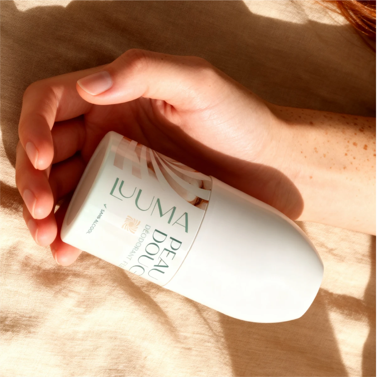 Deo fleur de coton tenu dans une main