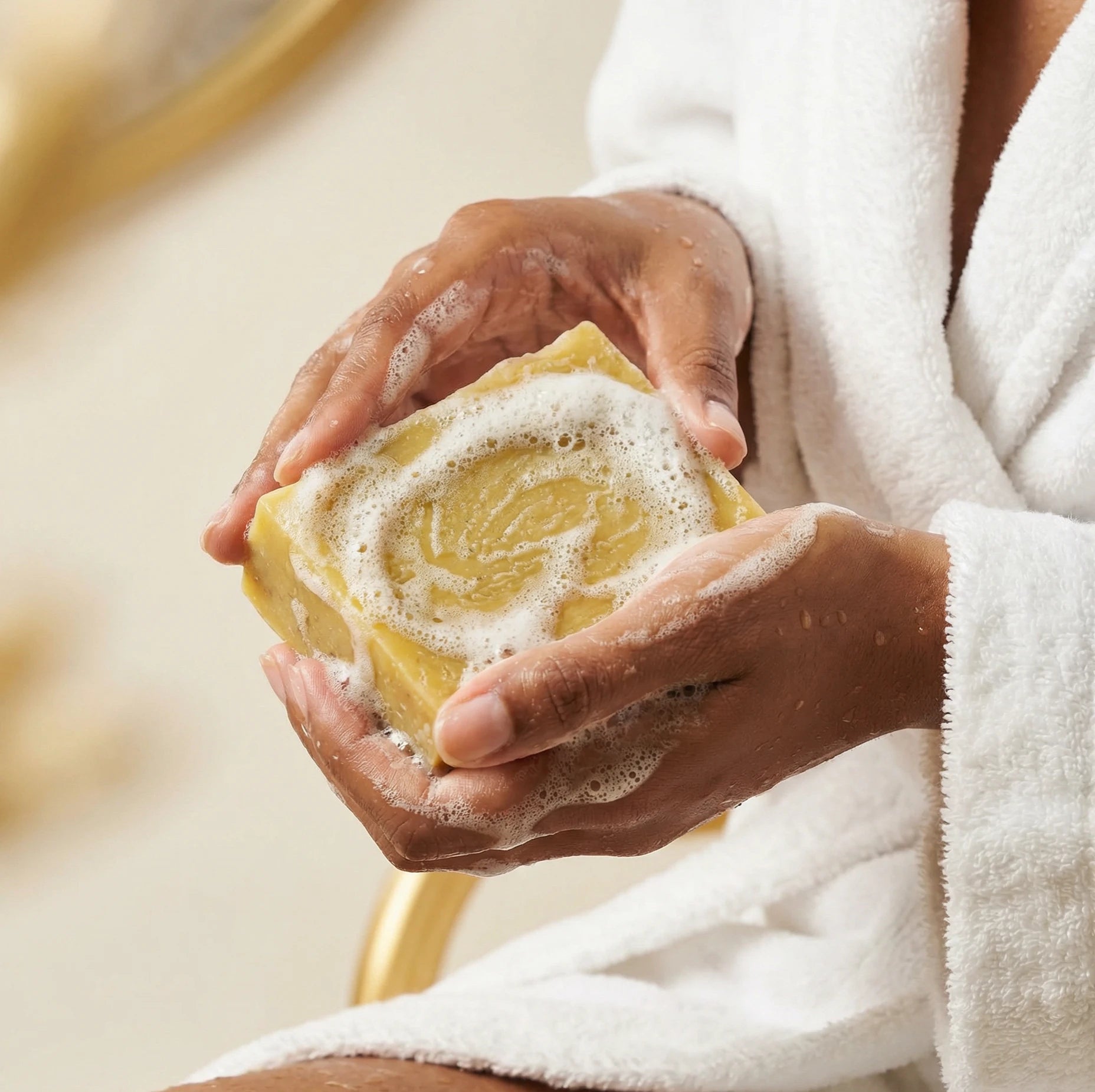 Savon au lait de chèvre et miel mousseux entre deux mains