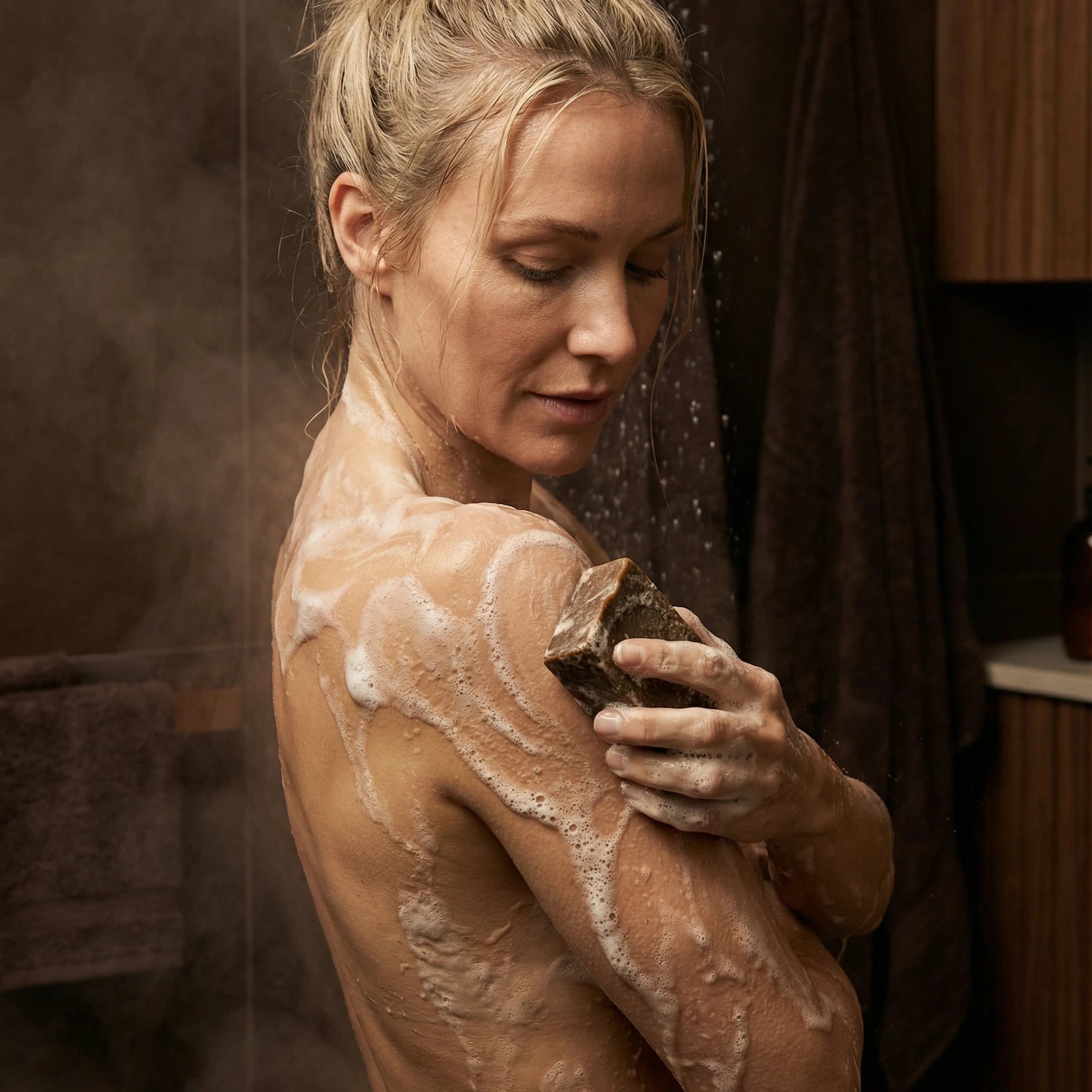 Savon à la vanille en cours d'utilisation sous la douche par une femme