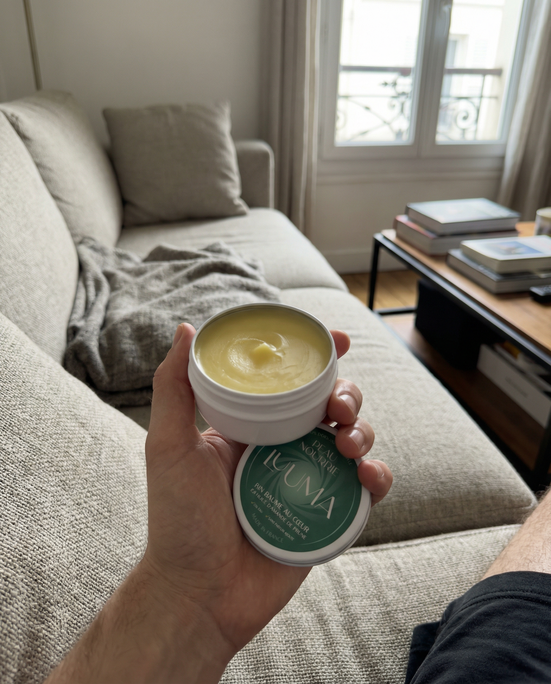Un baume est tenu en mains au dessus d'un canapé